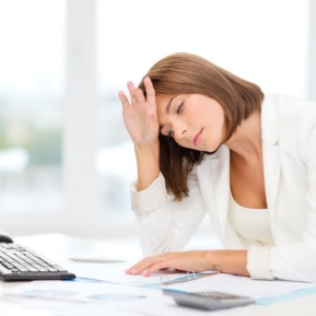 Tired Businesswoman With Computer And Papers